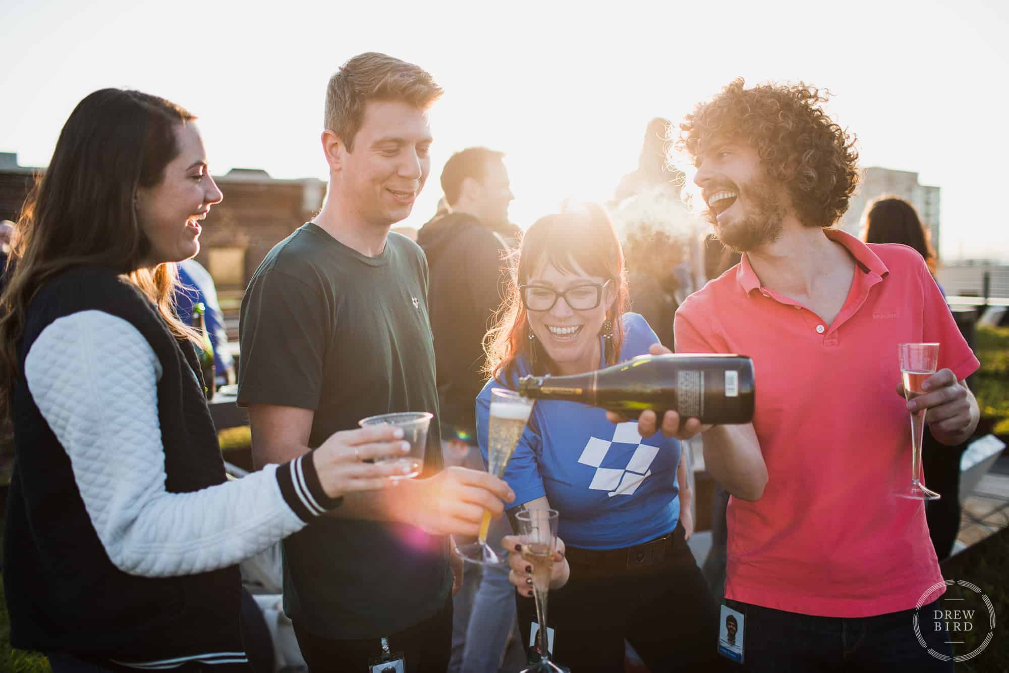 Group of people outside celebrating with champagne. Photo by San Francisco corporate event photographer Drew Bird.