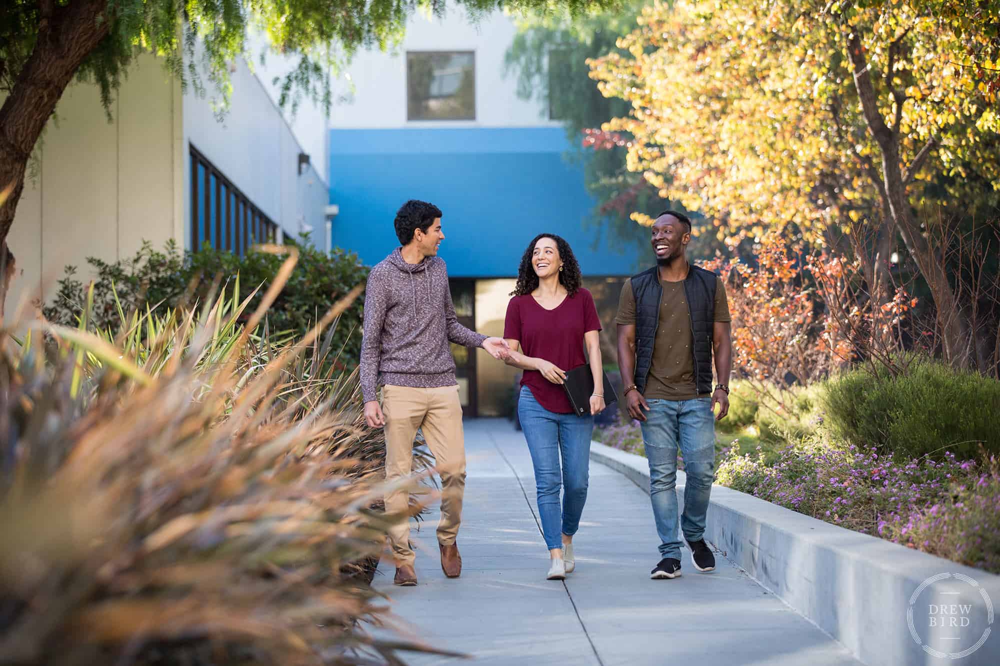 Two men and a woman, dressed casually, walking down a sidewalk. Photo by San Francisco based corporate lifestyle photographer Drew Bird.