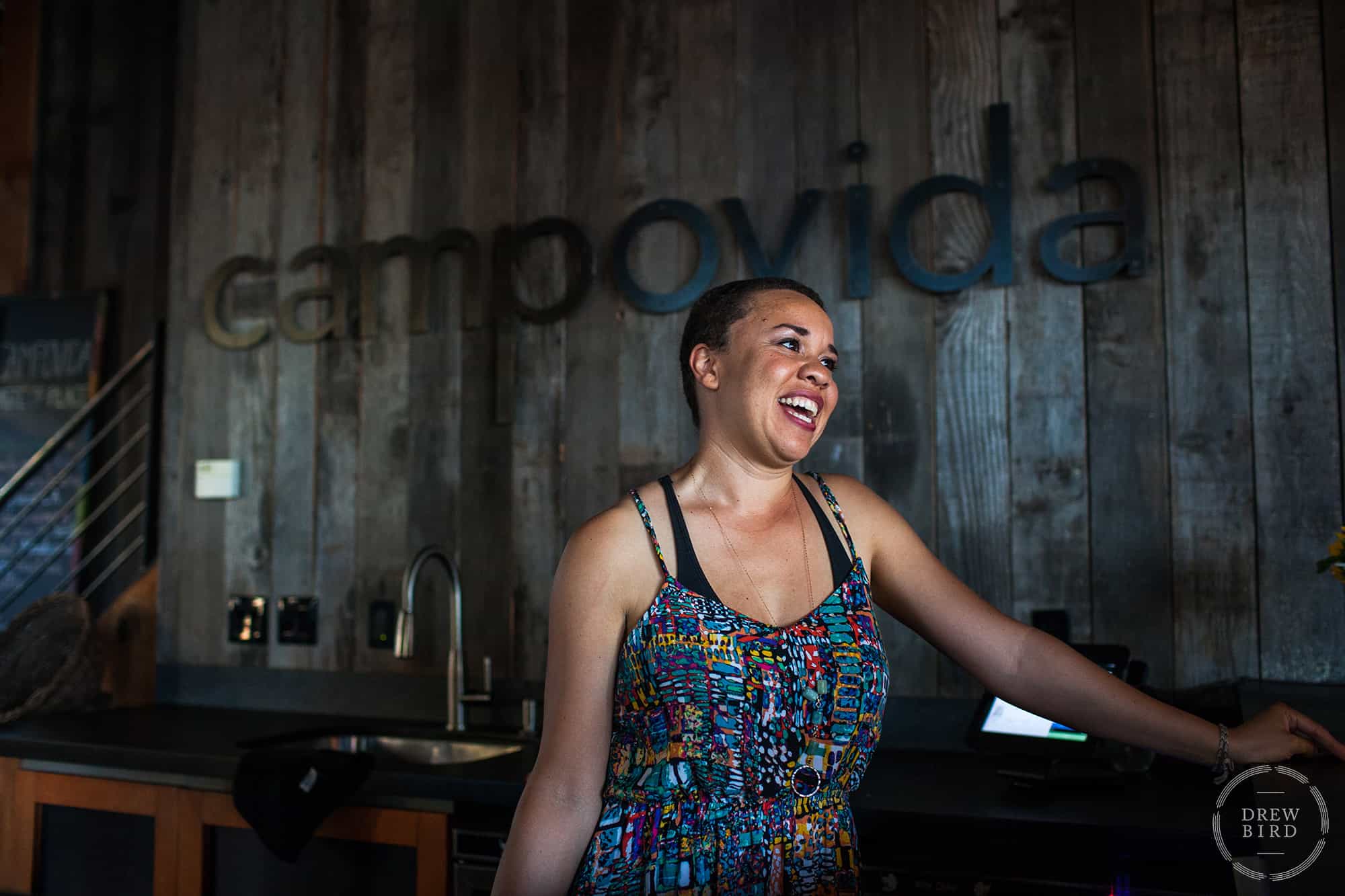 Smiling woman standing in front of a wood-paneled wall. Headshot by San Francisco based photographer Drew Bird.