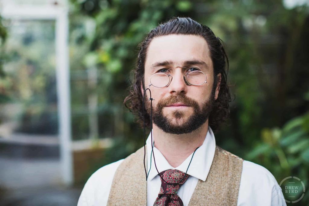 Man with spectacles and a beard at the conservatory of flowers. San Francisco editorial portrait and headshot photographer Drew Bird.