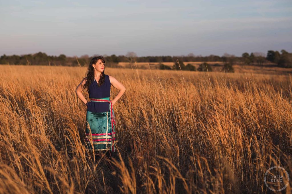 Woman standing in a field of wheat looking into the distance. Photo by San Francisco headshot photographer Drew Bird