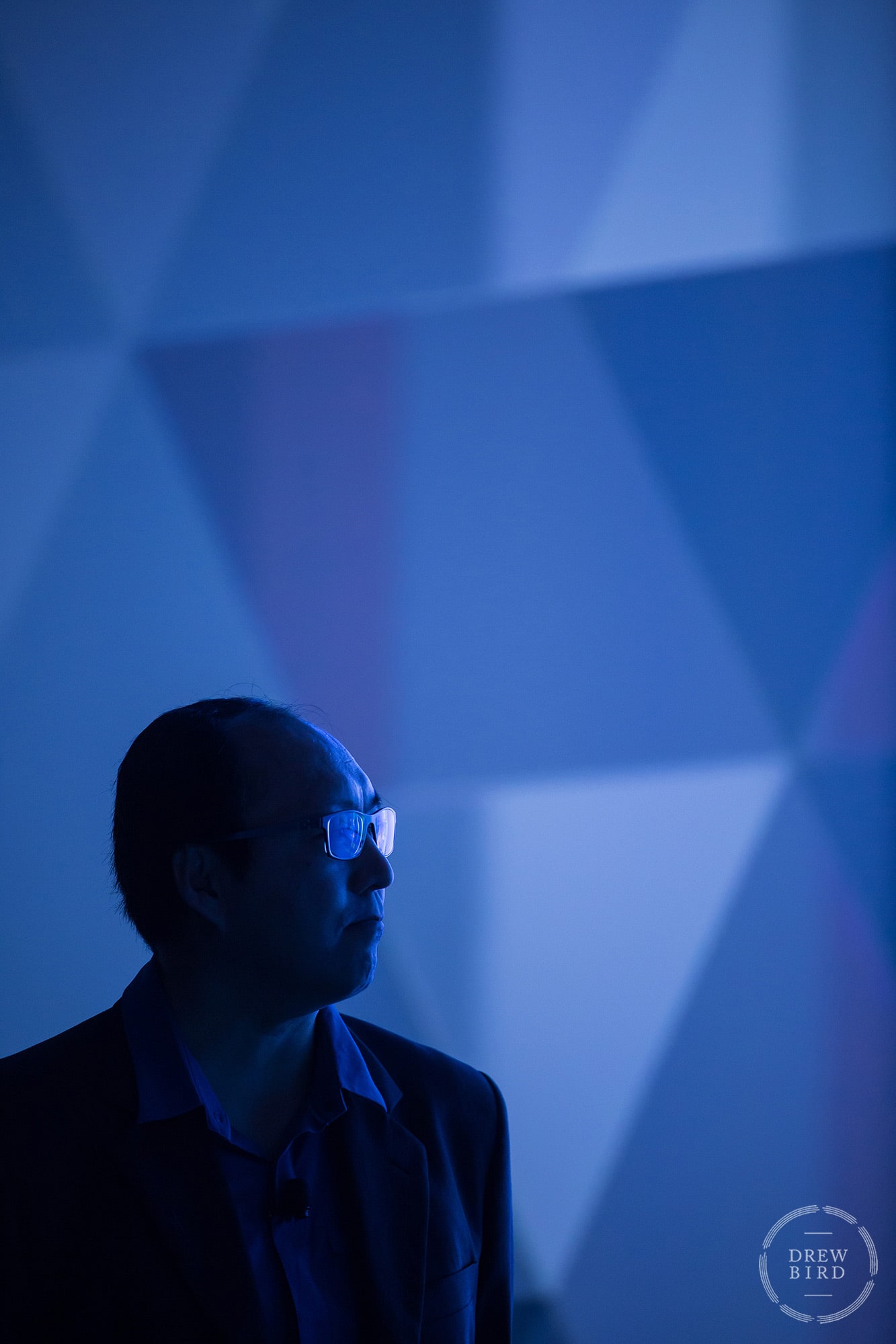 Man with glasses silhouetted against cool architectural shapes at the Moscone Center. San Francisco event photographer Drew Bird.