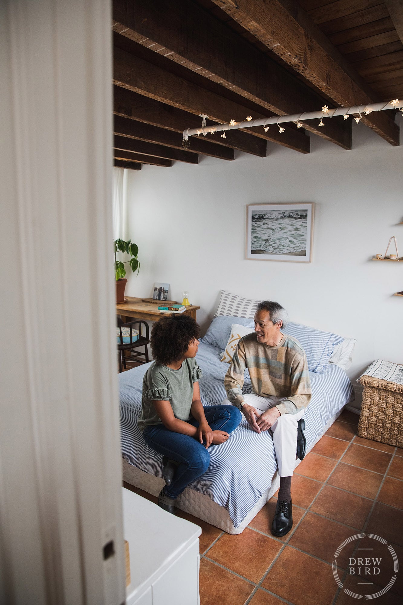 Father and his teenage daughter sitting on the corner of her bed in her bedroom talking. Unit Still photographer for movie production. San Francisco unit still photographer Drew Bird.